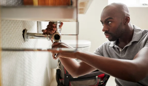 a male plumber fixing a bathroom faucet in Plano, TX - Plano, TX a male plumber fixing a bathroom faucet in Plano, TX - Plano, TX